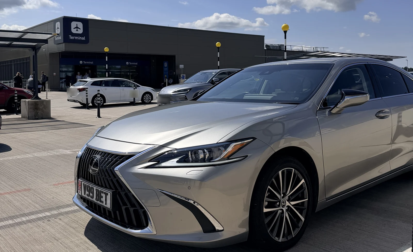 Beyond Elite Travel Lexus ES, plate V99 BET, waiting outside an airport terminal